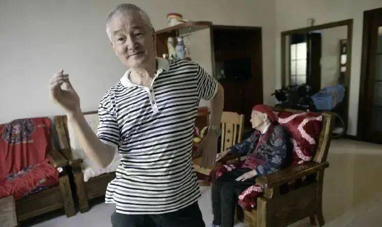 歌起,身动 75岁的重庆老人温后胜小心托起母亲 将她从轮椅上扶起,开始