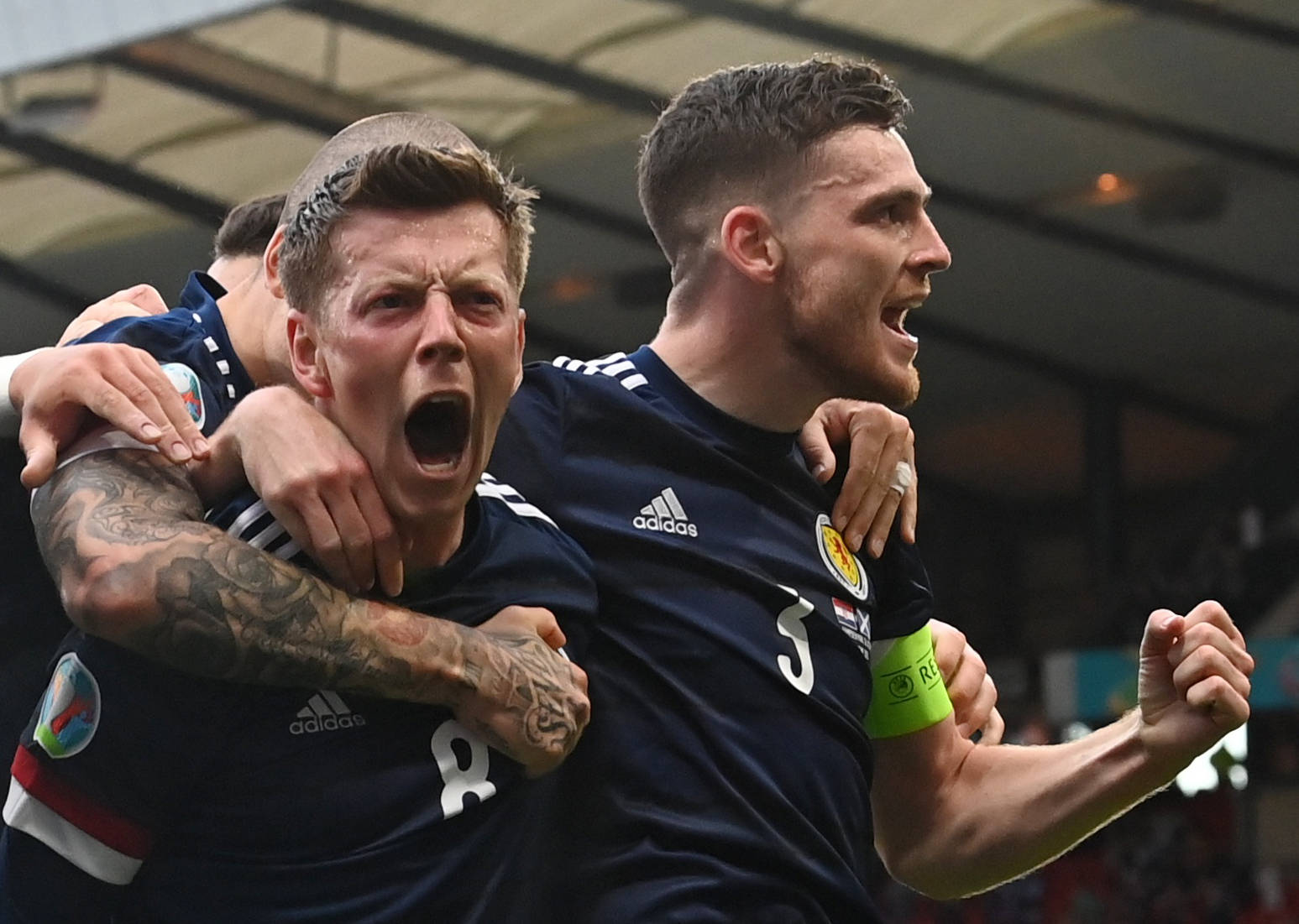 6月22日,苏格兰队球员麦克格雷戈(左)在比赛中庆祝进球.