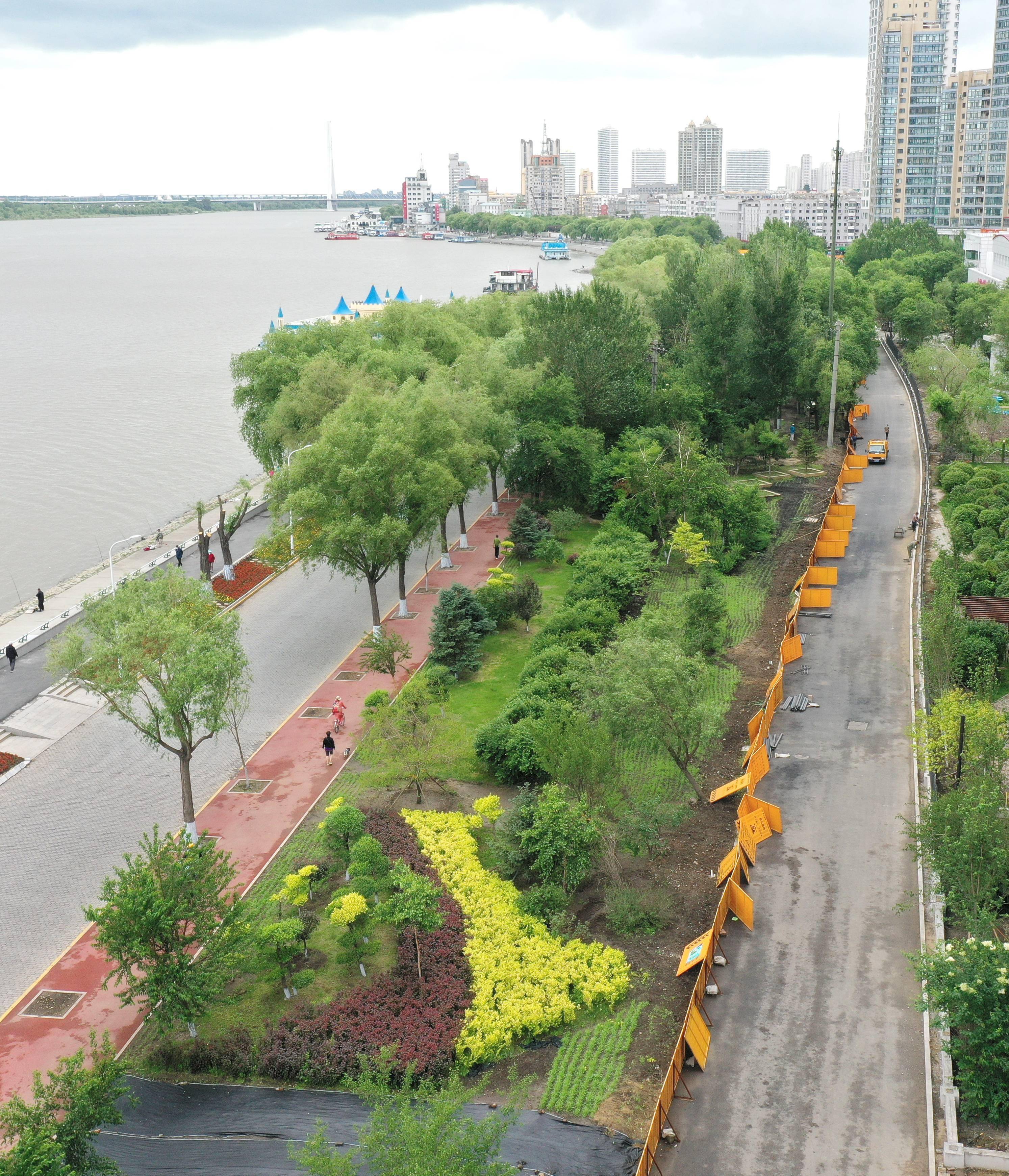 18日,哈尔滨市道外区江畔景阳广场至滨洲铁路桥间新建的道路上,工人们