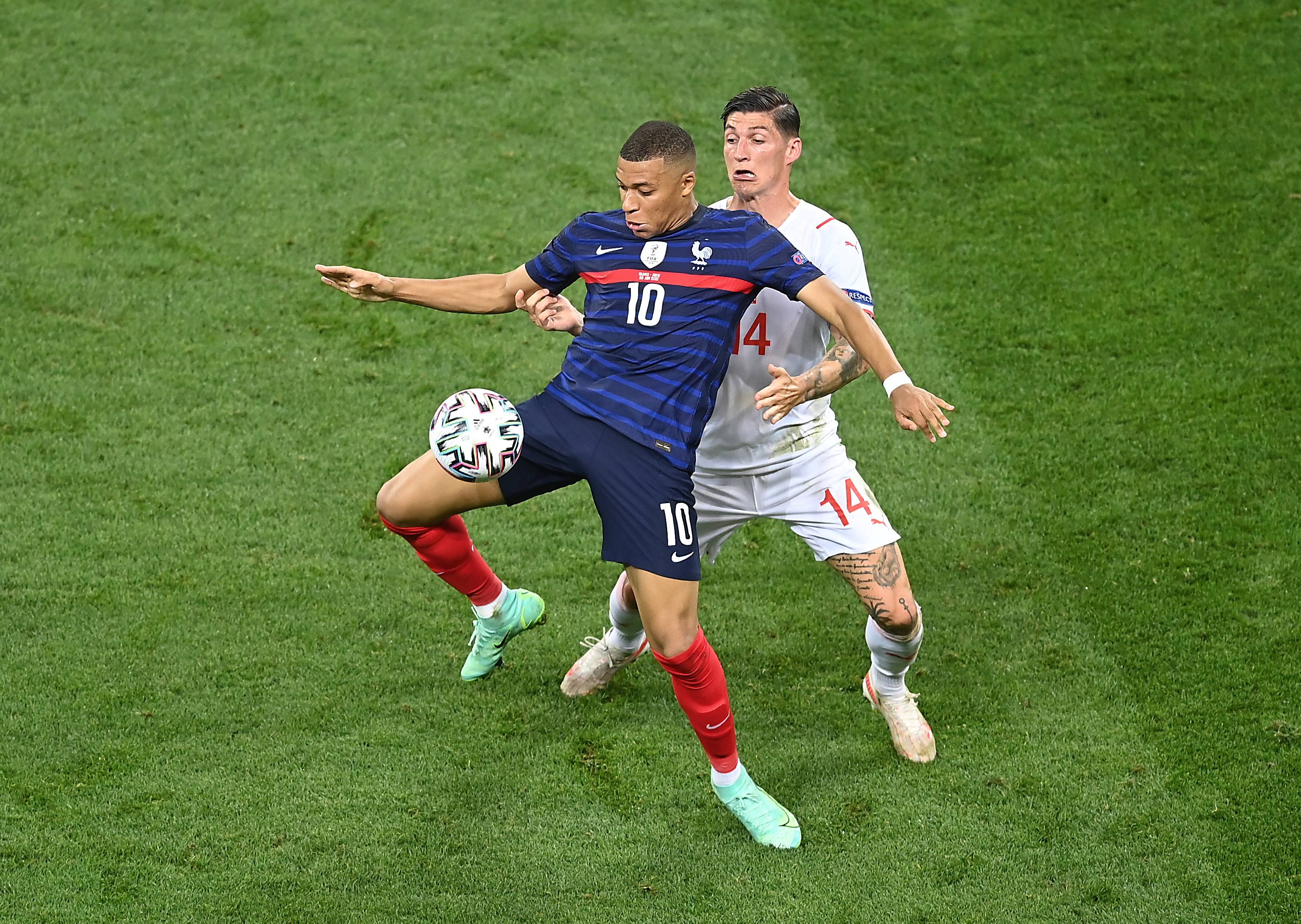 6月28日,瑞士队球员祖贝尔(右)与法国队球员姆巴佩拼抢