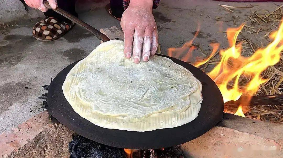 煎饼在农村用三块砖头放上鏊子,活点面汁,一把麦秸就是一顿美食.
