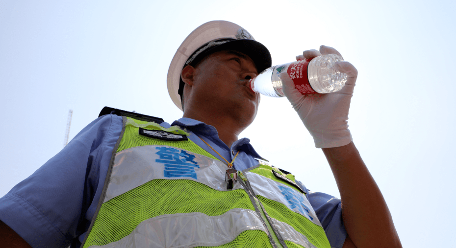 在忍受高温的炙烤路口执勤的交警全力维护道路交通秩序忍受着上面晒