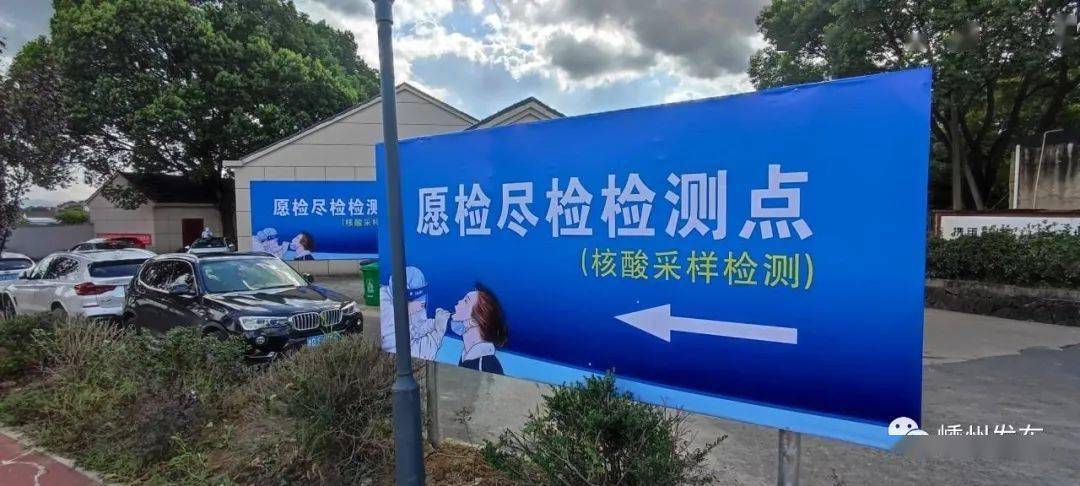 隔一条罗环路(罗小线),有醒目的"愿检尽检检测点"蓝色指示牌