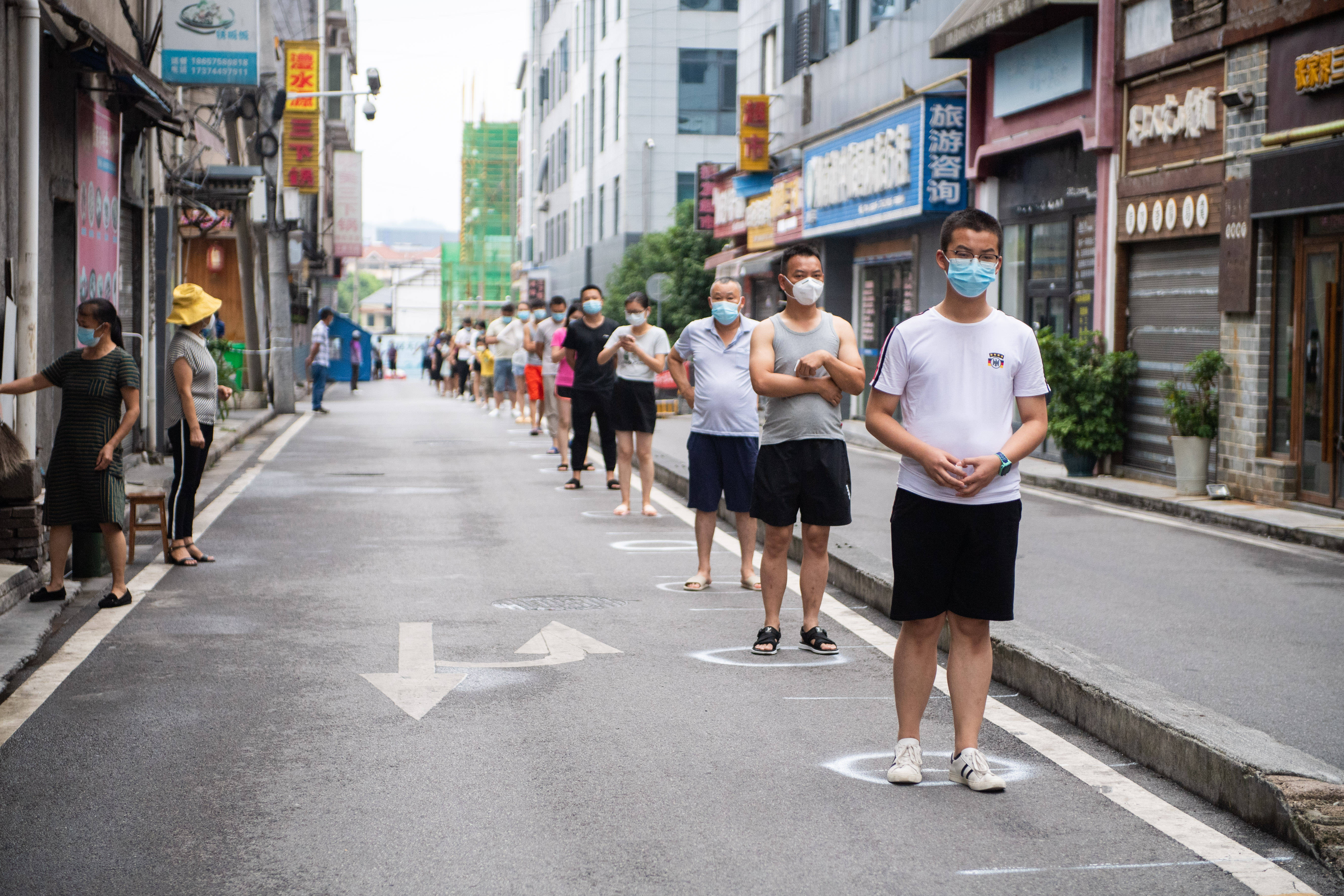 8月10日,在张家界市永定区官黎坪街道,居民排队等待做核酸检测