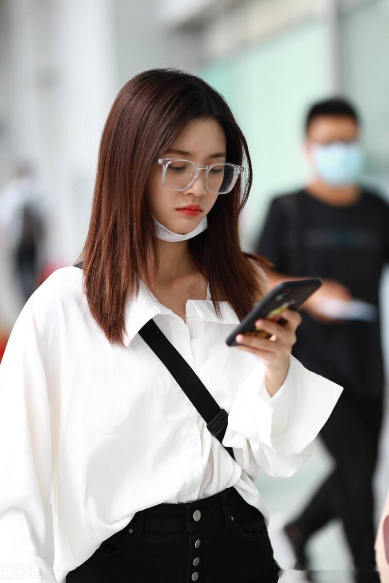 罗奕佳身穿斜肩衬衫搭配黑色微刺裤秀香肩,透明框架眼镜简单时尚