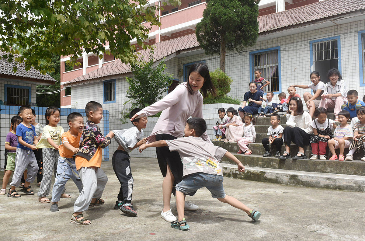 2021年9月7日,石盘寨小学,王锐茜老师正在和孩子们玩"老鹰捉小鸡"游戏