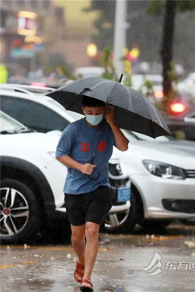 一位行人穿着凉鞋在雨中小跑
