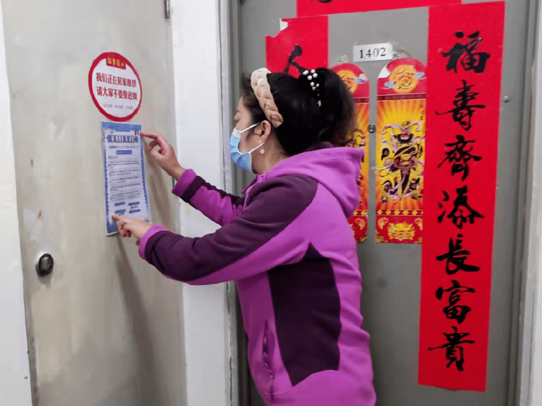 社区工作人员在居家隔离人员门口张贴温馨提示