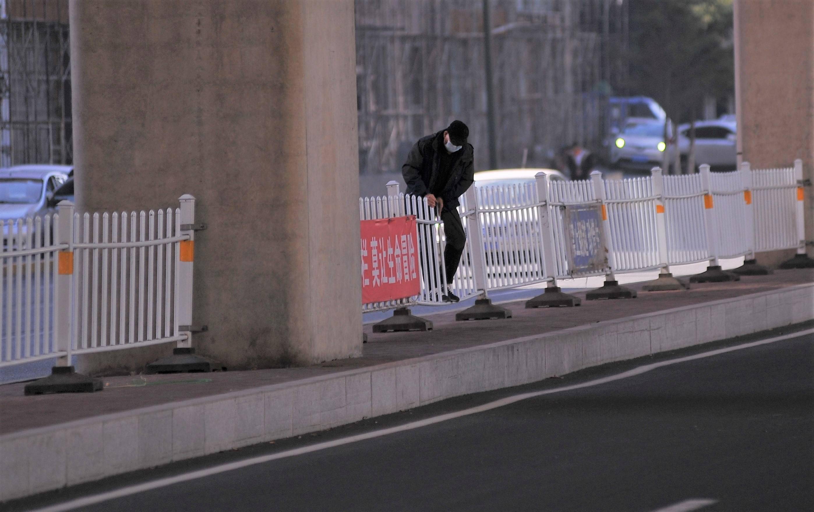道路隔离栅挡不住行人抄近道的心,过街天桥就在不远处却不愿多走