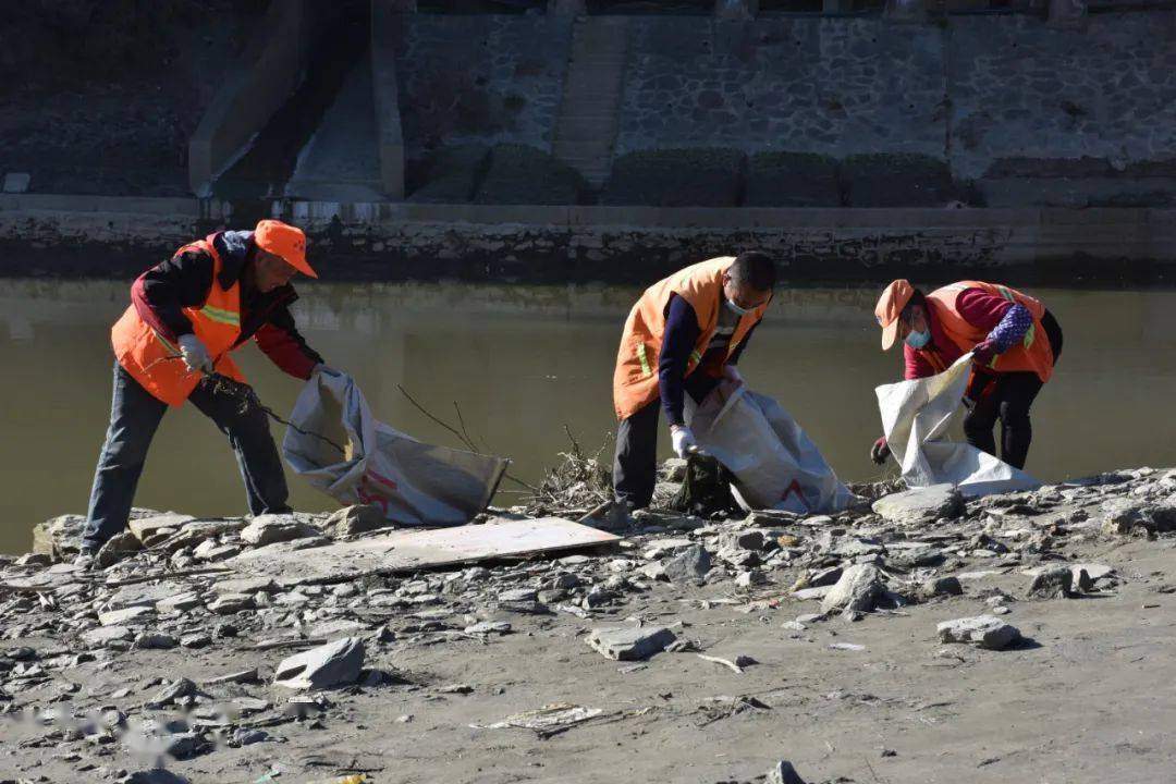 在整治中,工作人員手拿塑料麻袋分組沿河道拾撿垃圾,重點對河道內垃圾