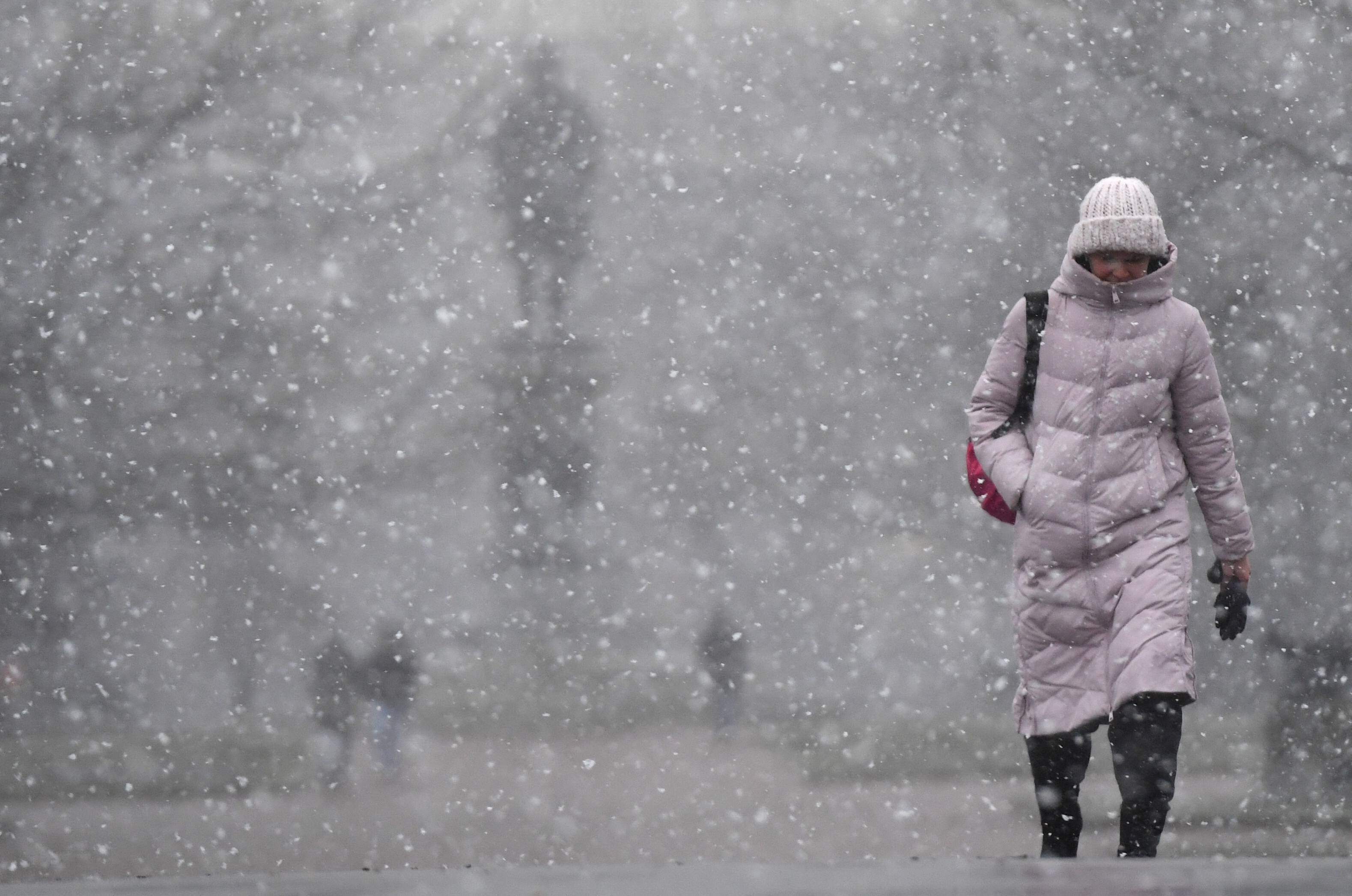 11月30日,一名行人走在俄罗斯莫斯科下雪的街头.