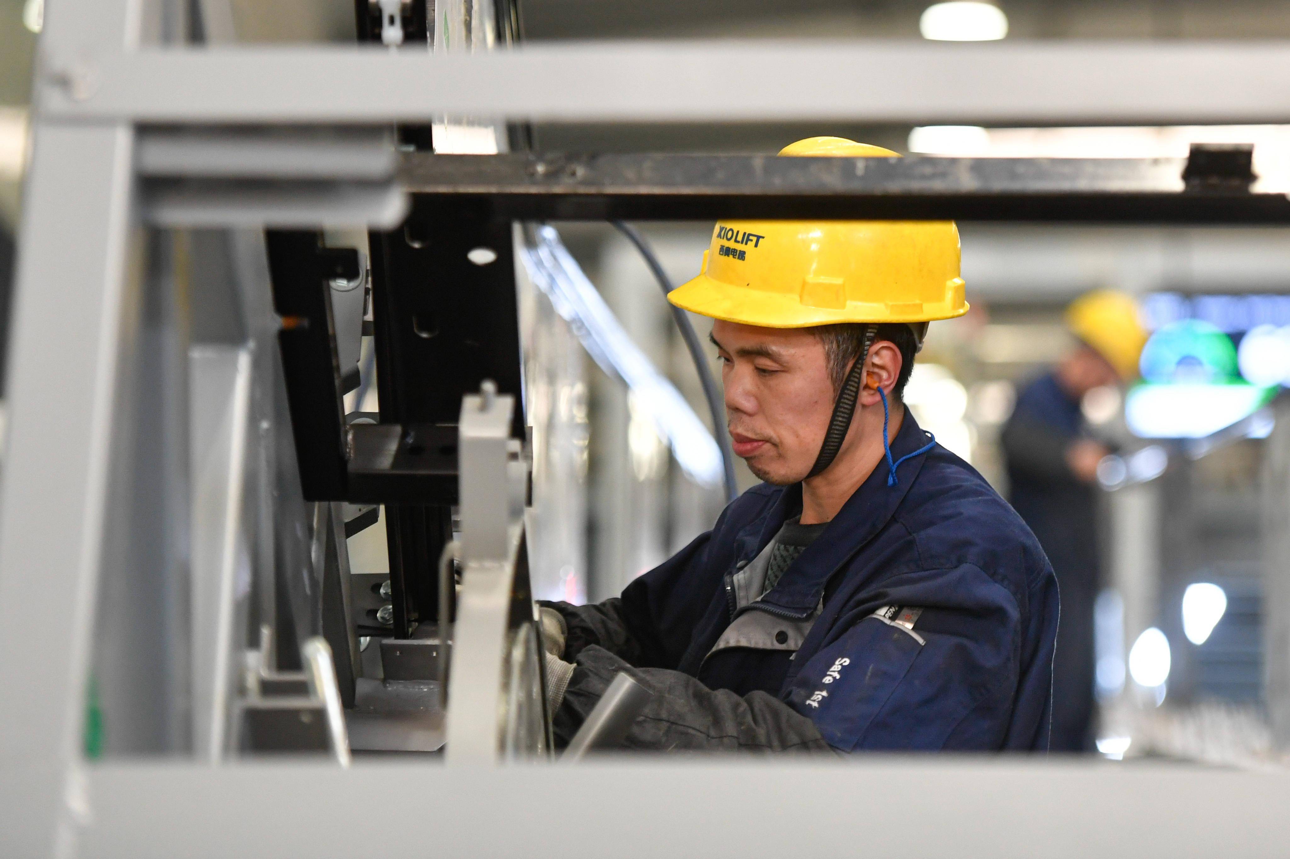 12月17日,工人在位于杭州市临平区的西奥电梯数字工厂内的自动化智能