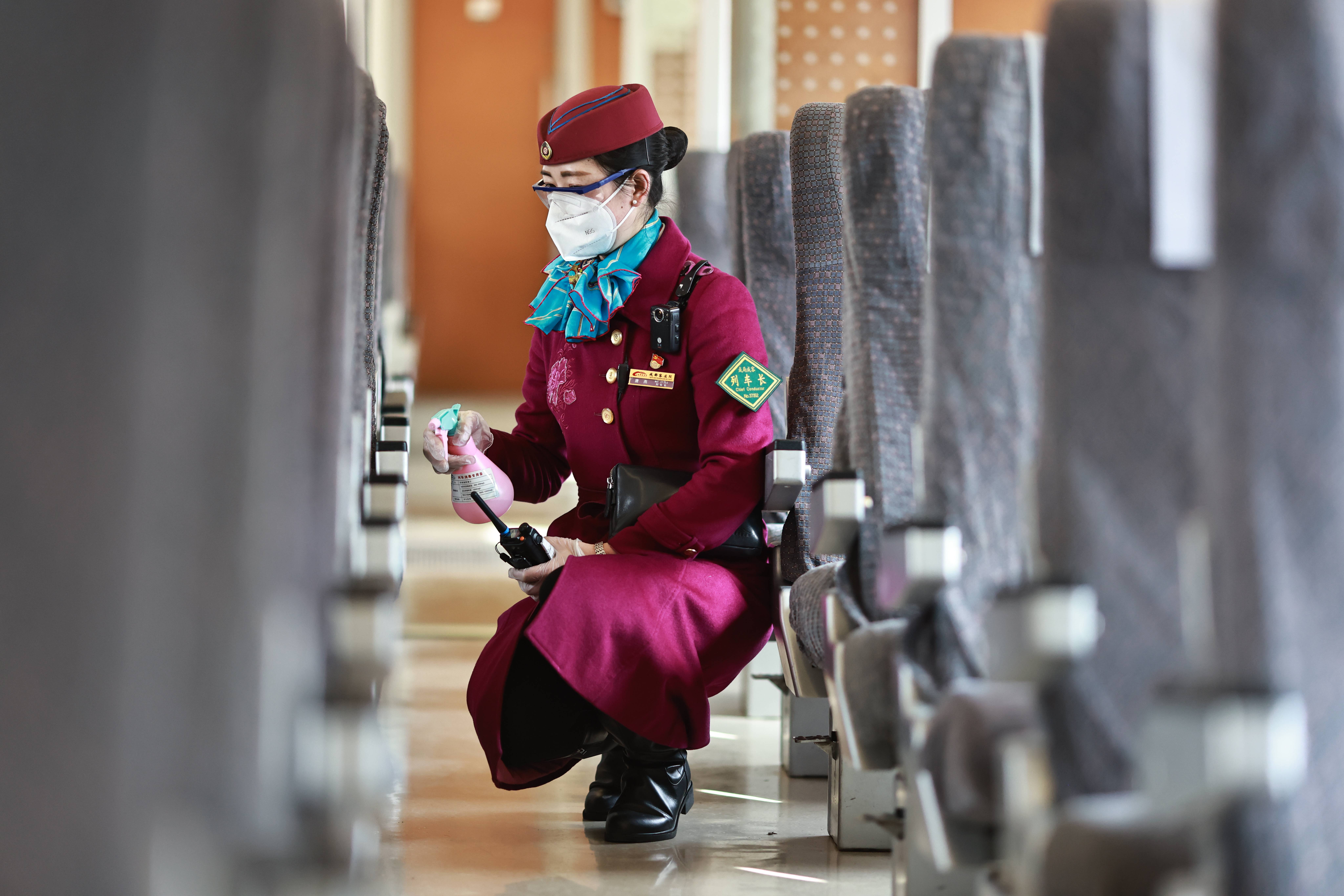 成都客运段城际动车一队列车长唐燕在车厢内进行防疫消毒(摄:苏志刚)