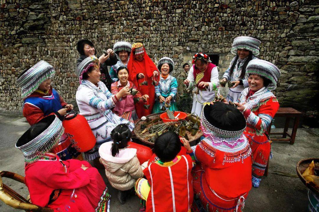 少数民族妇女围坐一起,包粽子,过新年.村民晒制当地特色小吃玉米饼.