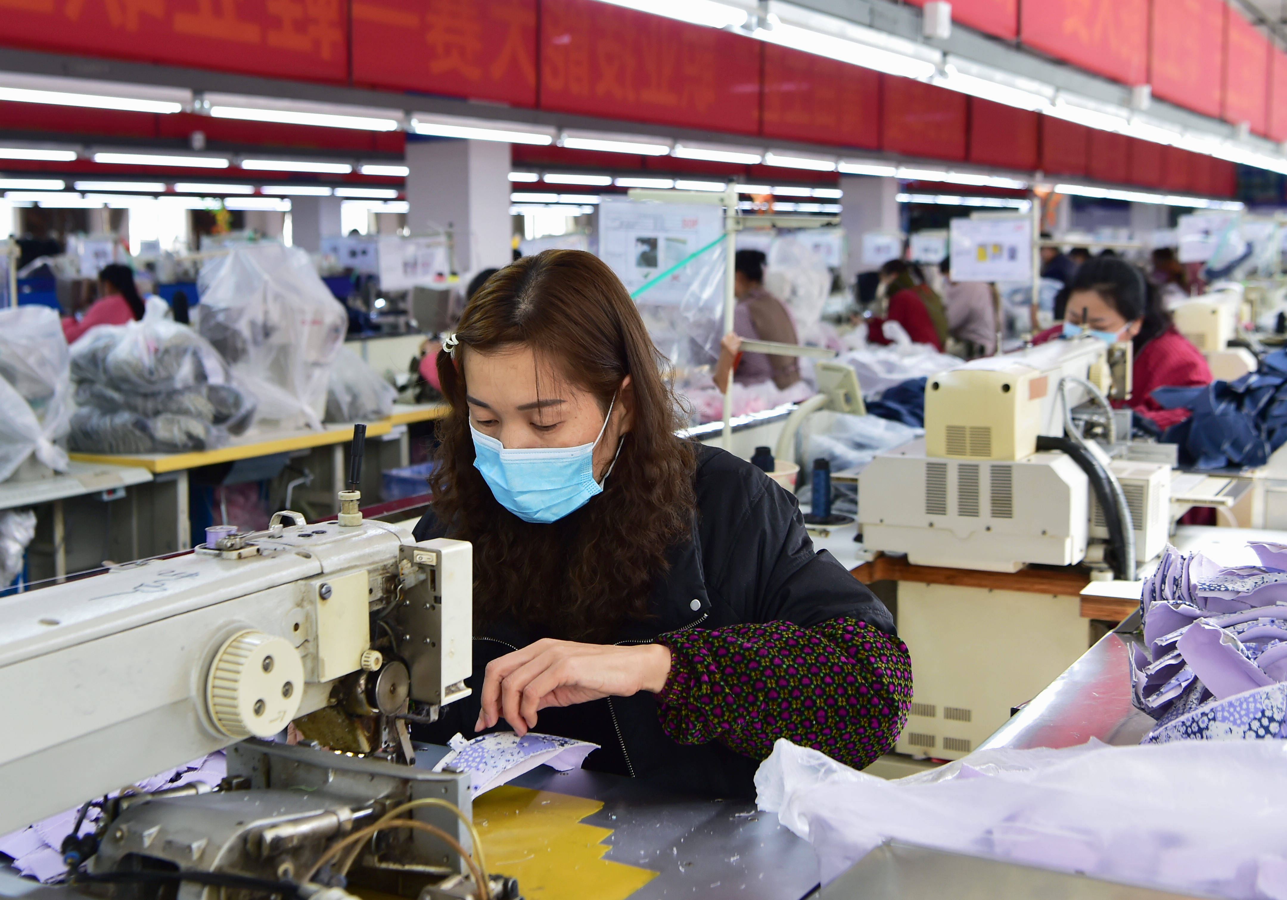 在莆田的一家鞋企生产线上,工人们正使用电脑自动印刷机生产运动鞋