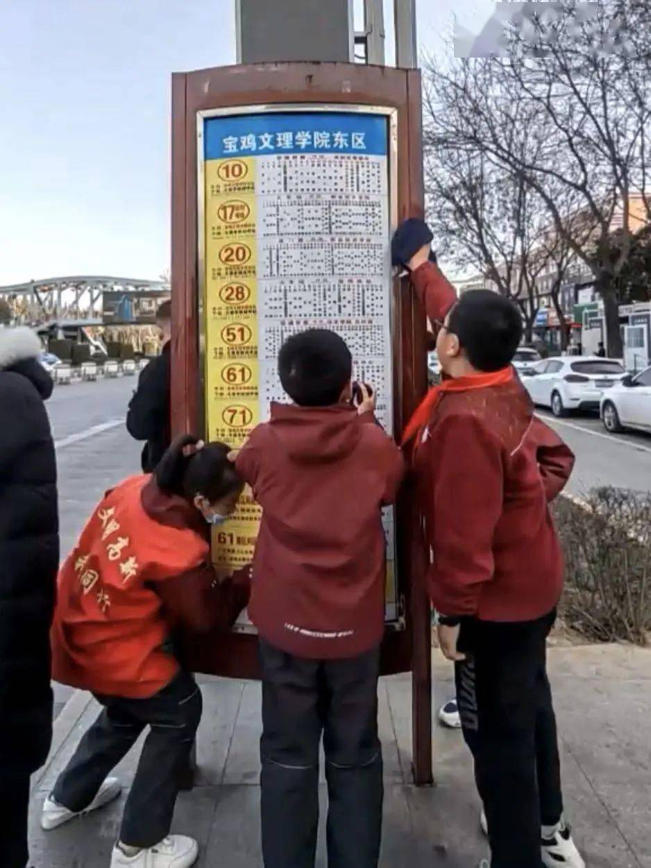 少先队员们走上街头参加志愿服务活动,擦拭公共汽车站的站牌,座椅和