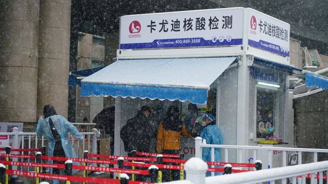 3月18日,北京西站站前广场,入境检查口外的核酸检测点,工作人员正在