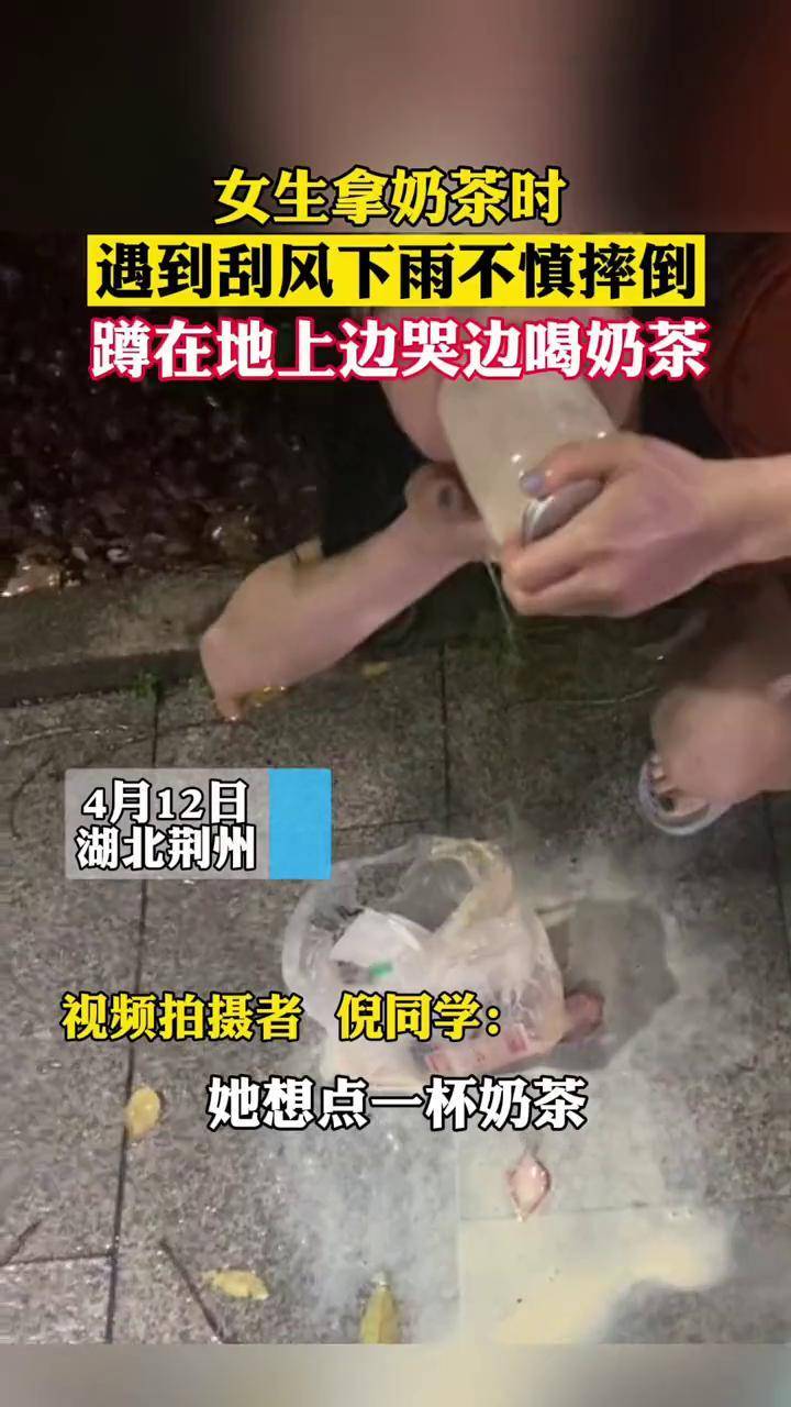 女生拿奶茶時遇到颳風下雨不慎摔倒蹲在地上邊哭邊喝奶