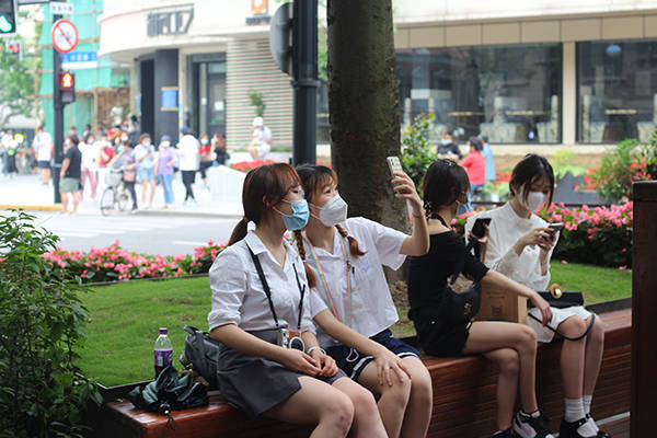 上海武康路的下午：人们穿着清凉来打卡，服装店内还摆着春装