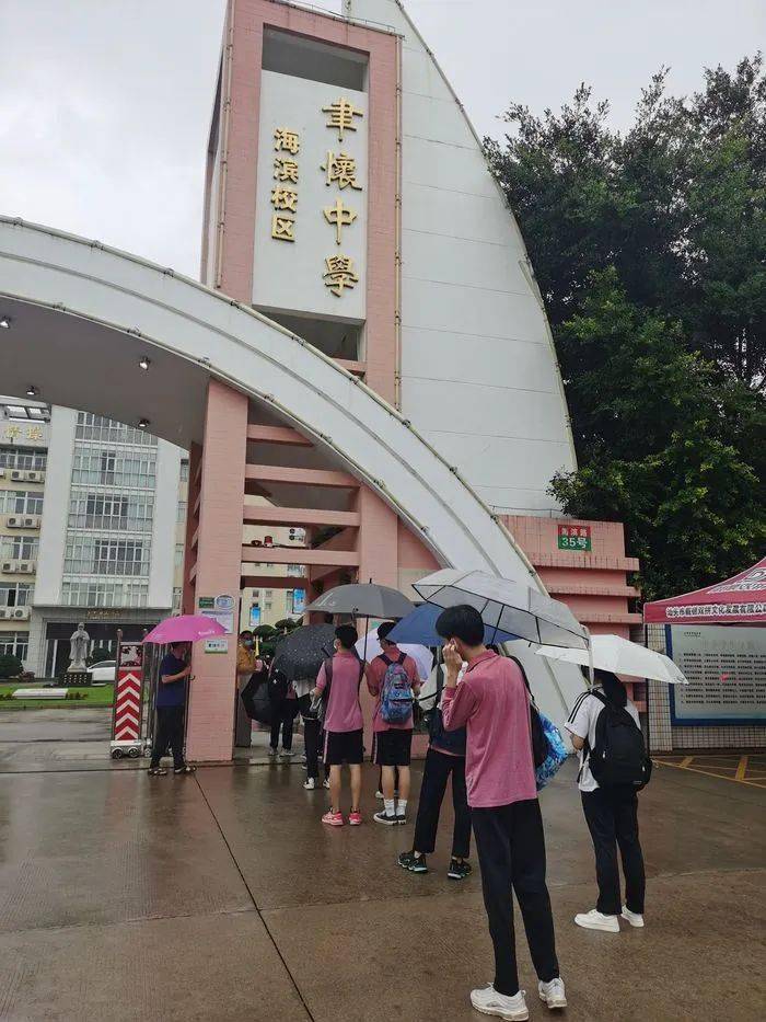 车辆陆续抵达聿怀中学海滨校区,考生陆续下车,老师逐一和考生击掌,为