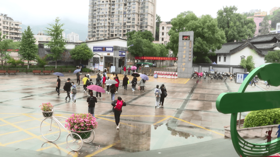 考生郭正阳在青田二中考点门前,参加中考的考生们按要求佩戴口罩,手持