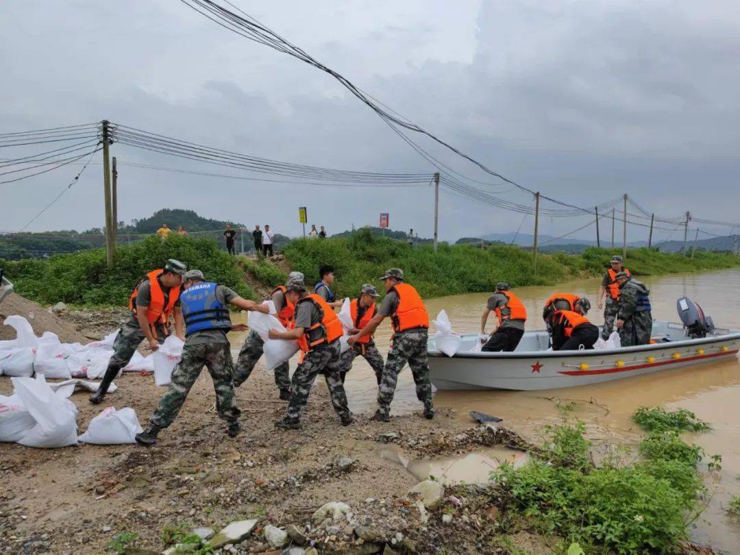 佛冈龙山镇,救援人员运送沙包封堵河堤.