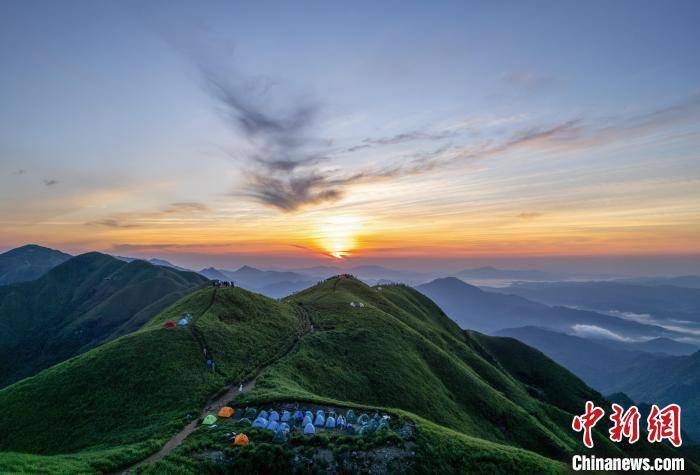 航拍江西武功山壮美日出 高山草甸绿意盎然帐篷满山顶