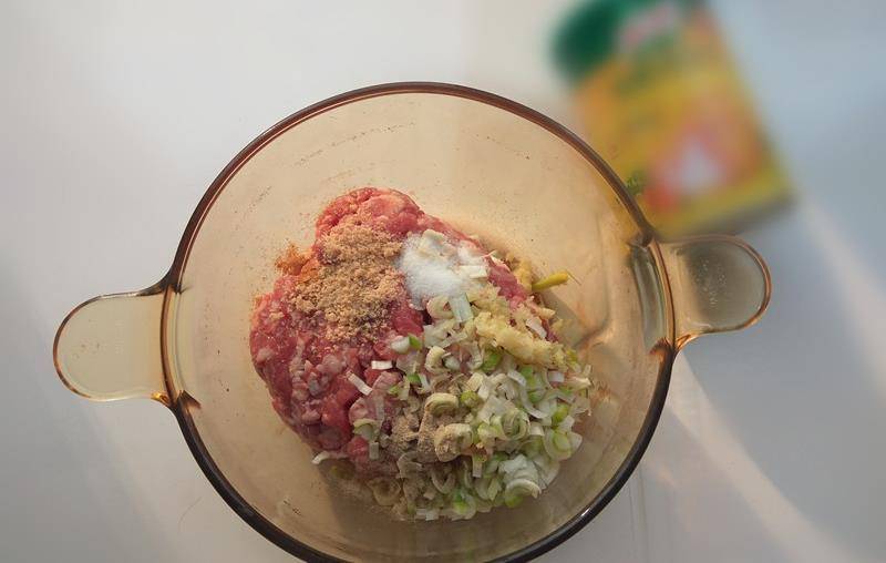 将肉馅放在大碗内,加入葱姜末,盐,胡椒粉,料酒,鸡蛋,用筷子顺一个方向