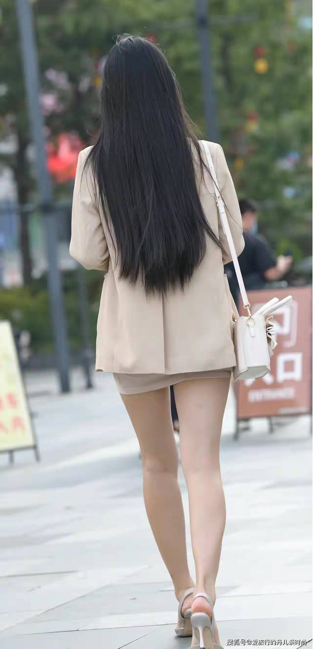 美女身穿卡其色长款西服搭配米色包臀裙,脚踩白色高跟鞋,优雅大方又不