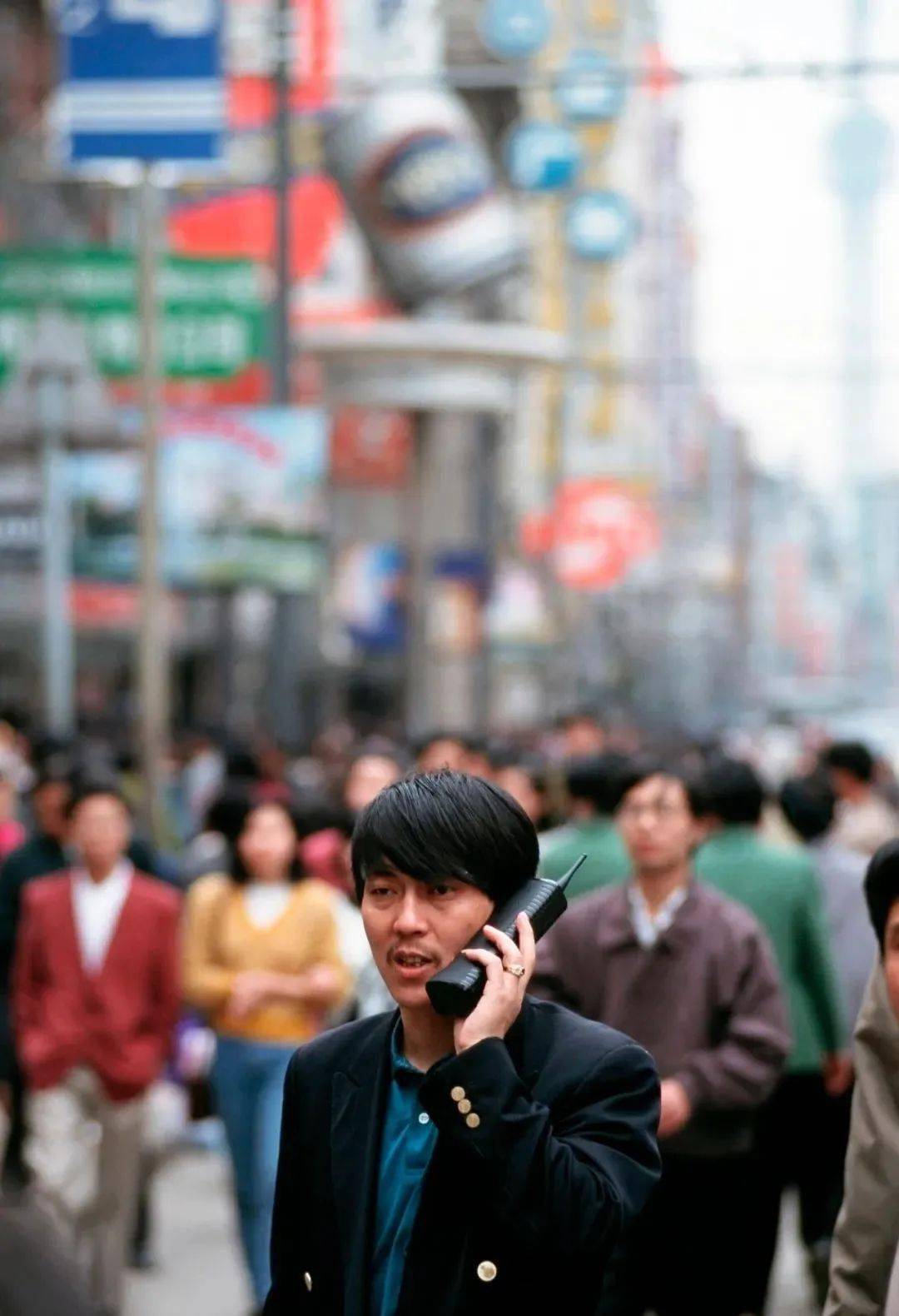 拿着大哥大的男人老师在指导模特聚餐的几位女士街头三位时尚女性