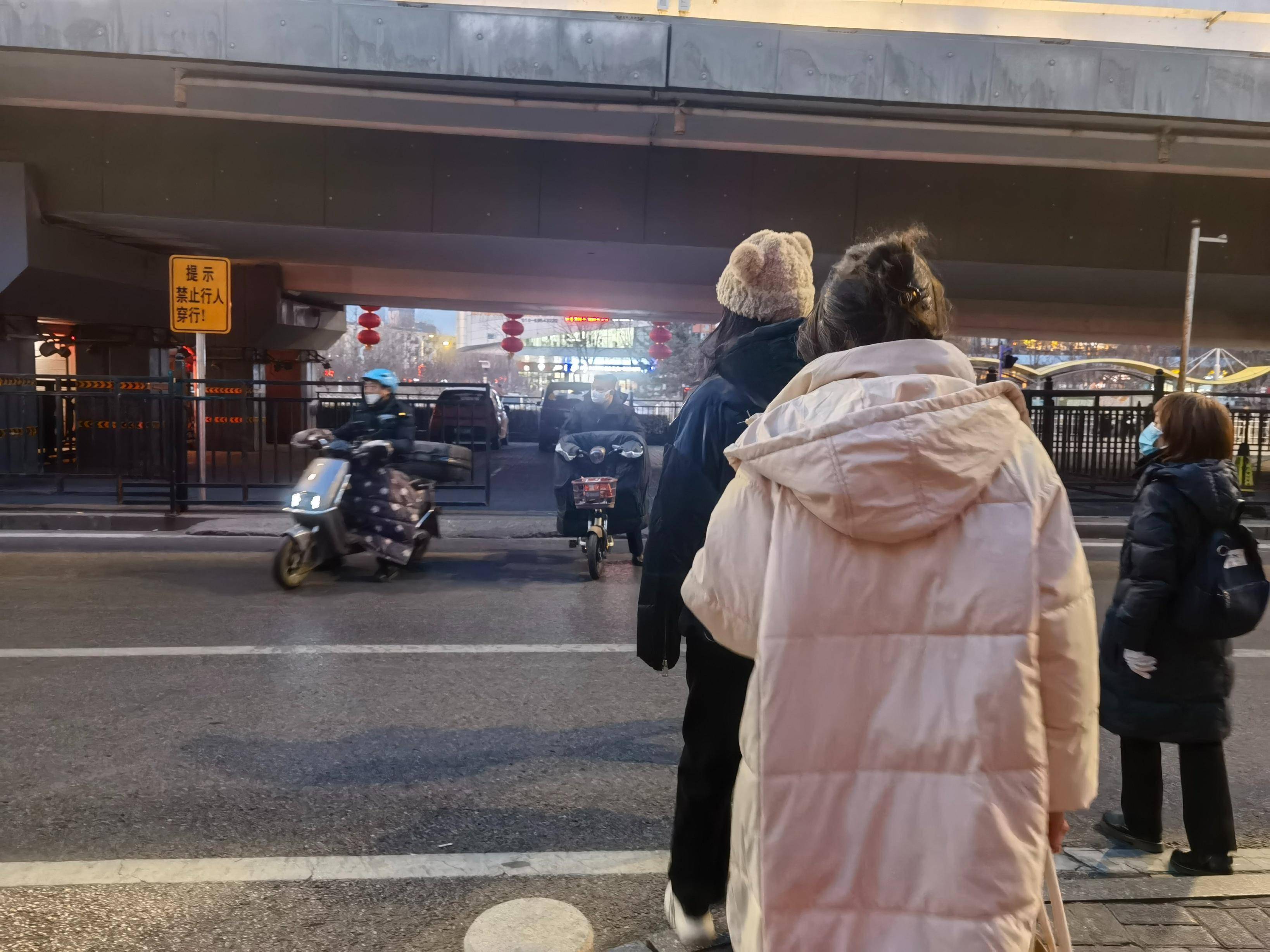 横穿马路,不少外卖车辆,电动车也夹在人群里伺机通过桥洞骑到马路对面