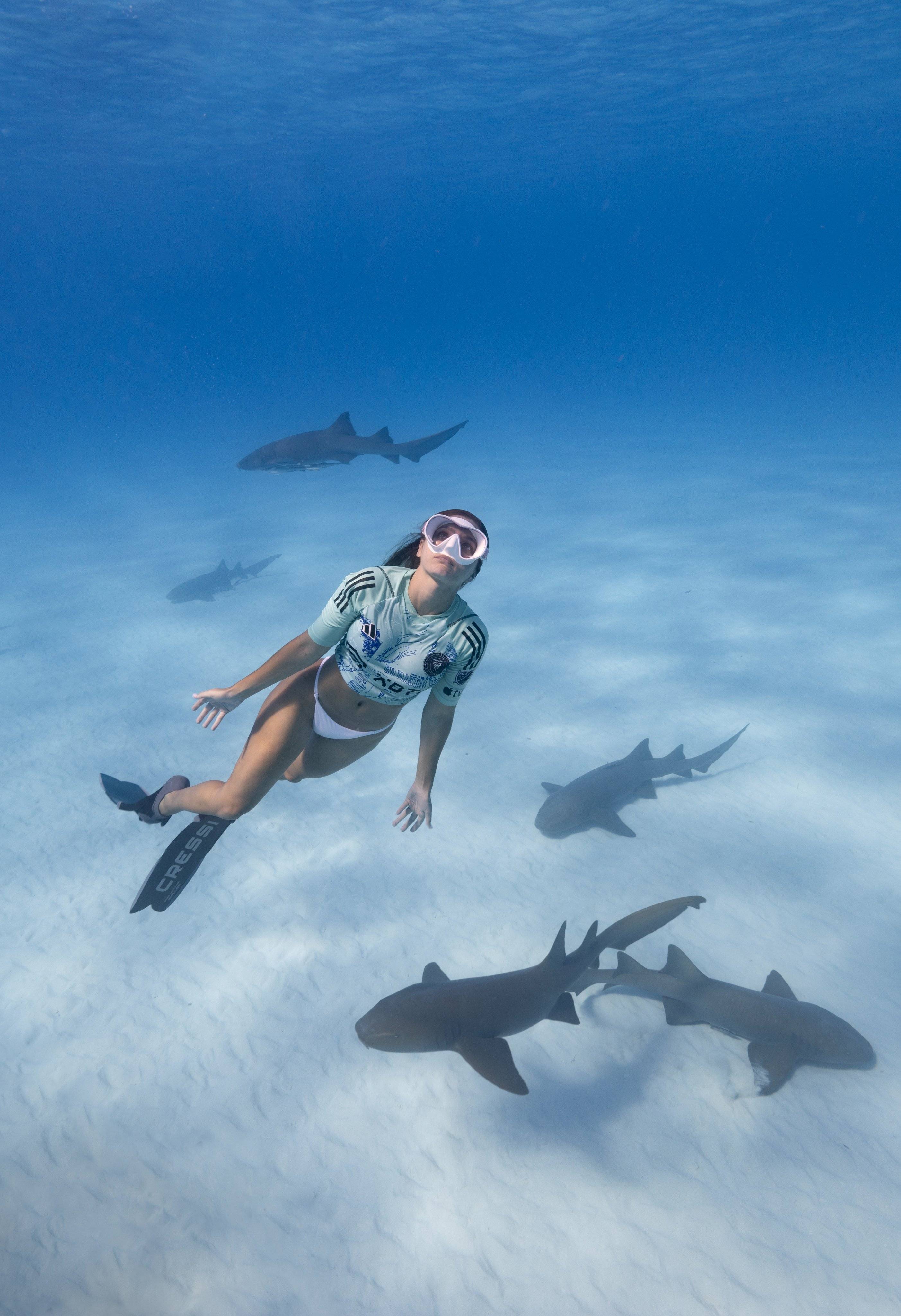 女潜水员为迈阿密国际特别球衣拍宣传片,在水下与鲨鱼共舞