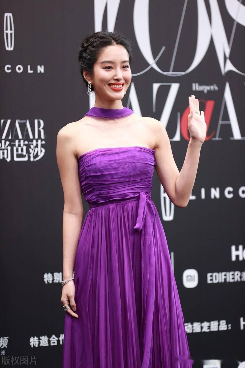 杨采钰身穿紫色挂脖飘带百褶抹胸裙自信大方