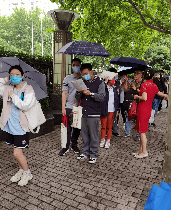 盧灣高級中學考生張昊君和王立濤拿著祝福語的手舉牌為考生加油身穿