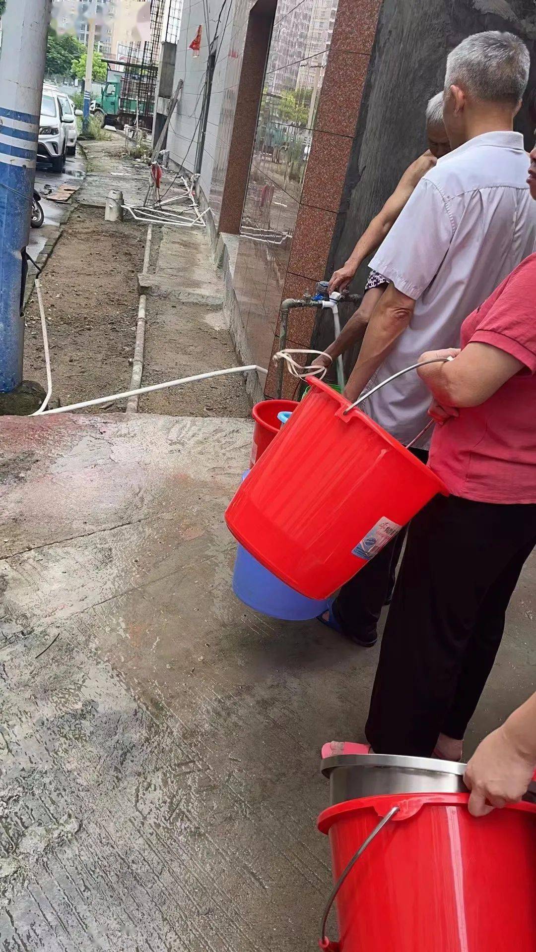 业主排队打水,业主们询问是否水管质量问题,温度变化较大时管道才容易