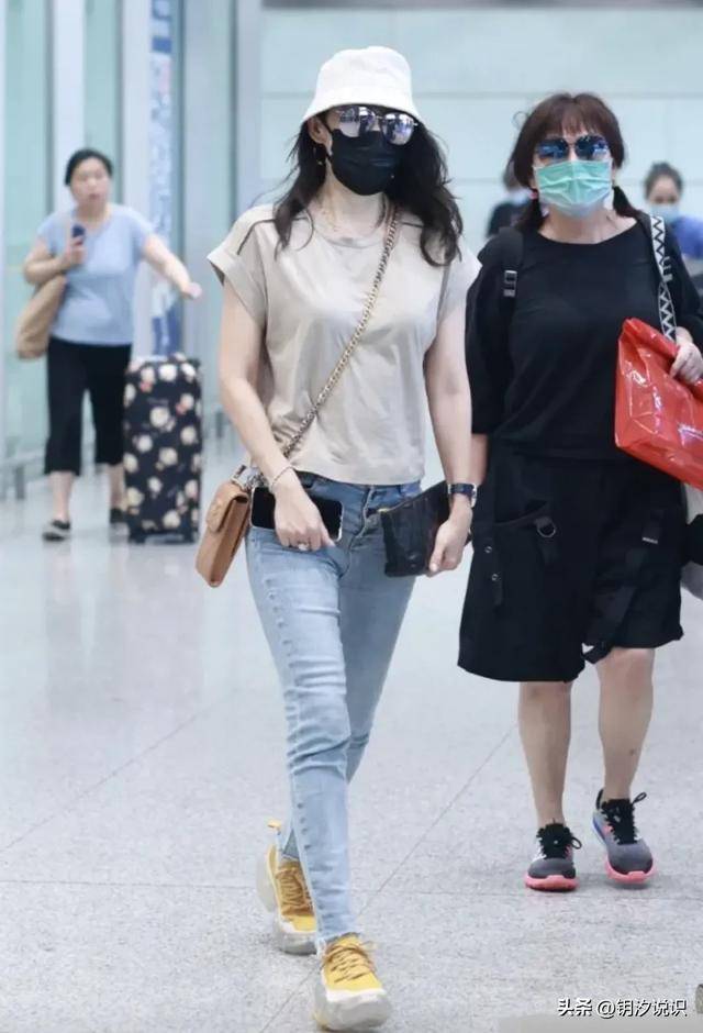 章子怡机场亮相,灰色的t恤搭复古风牛仔裤,潇洒迷人气质出众.