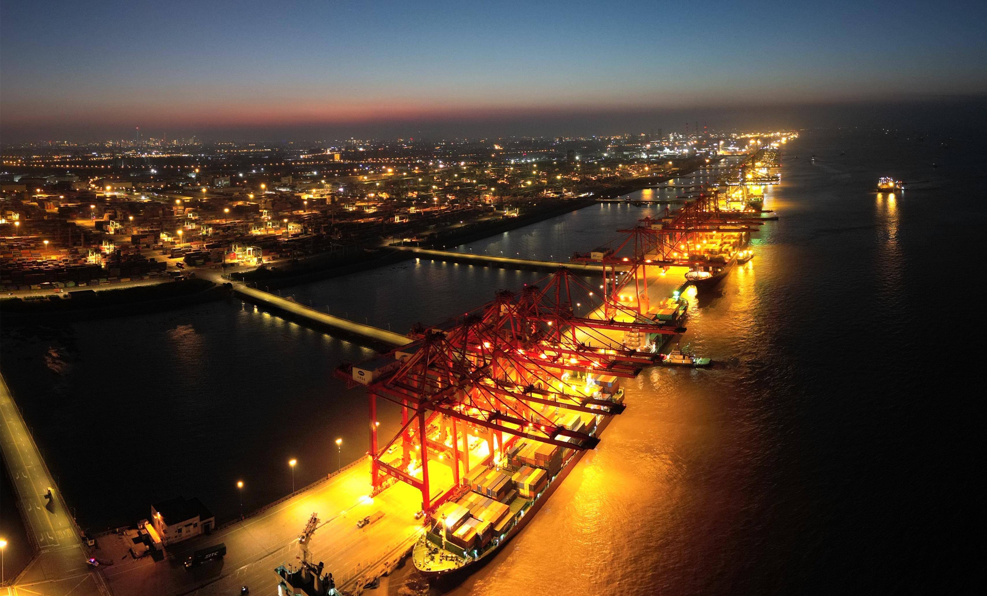 7月27日深夜,上海外高桥口岸灯火通明,停靠在泊位上的集装箱船正在有