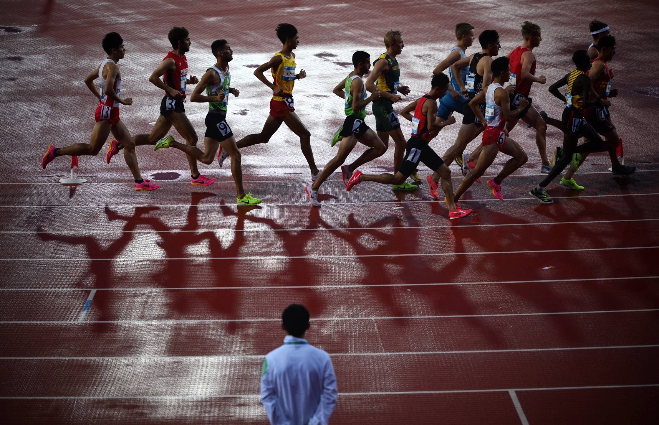 男子4×400米接力决赛,选手在进行交接棒.女子跳高决赛,选手过杆瞬间.