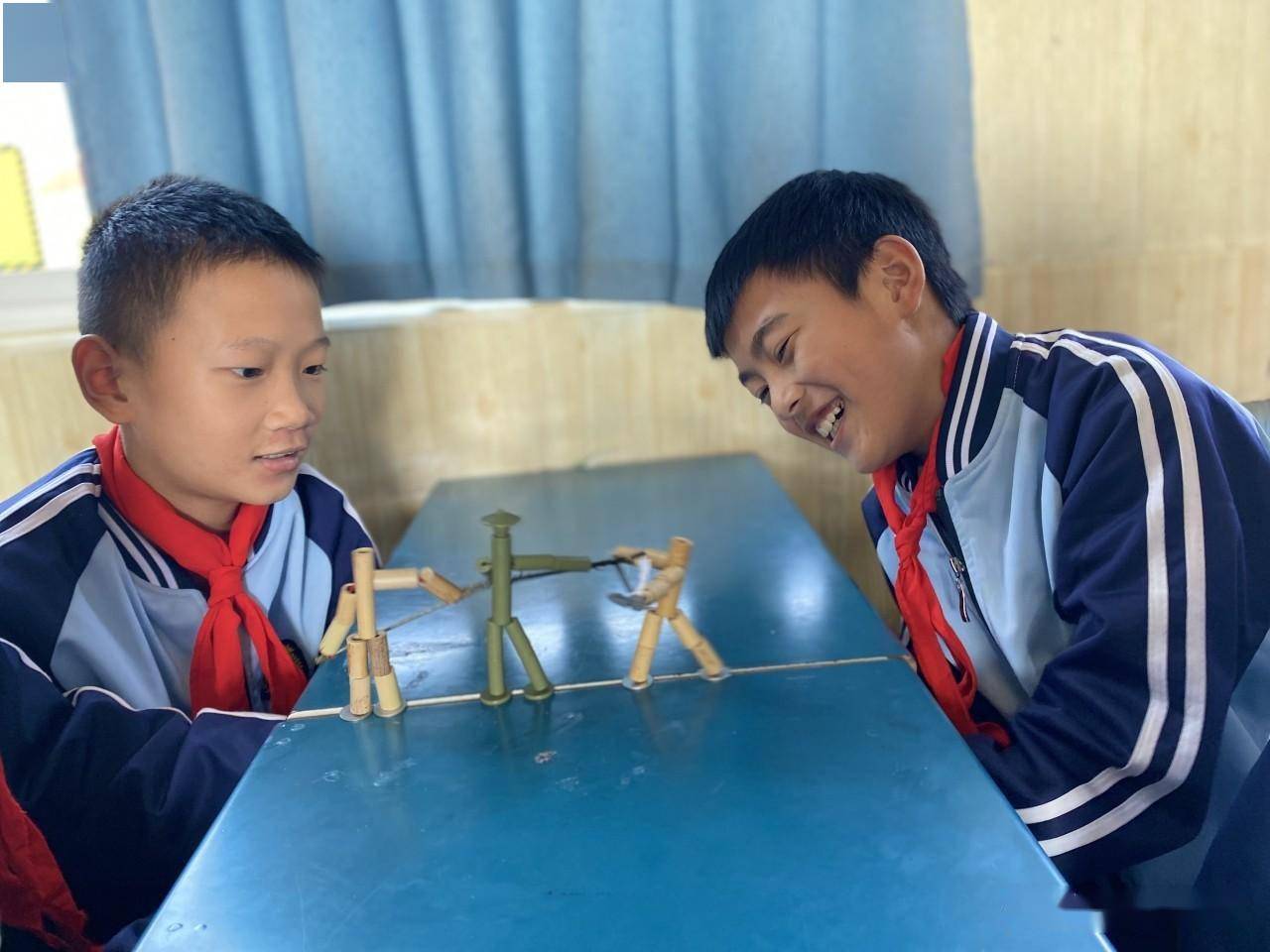 只见他们拿出竹节人,将线插入桌子的缝隙中,双手拉动着线,"竹节人"就