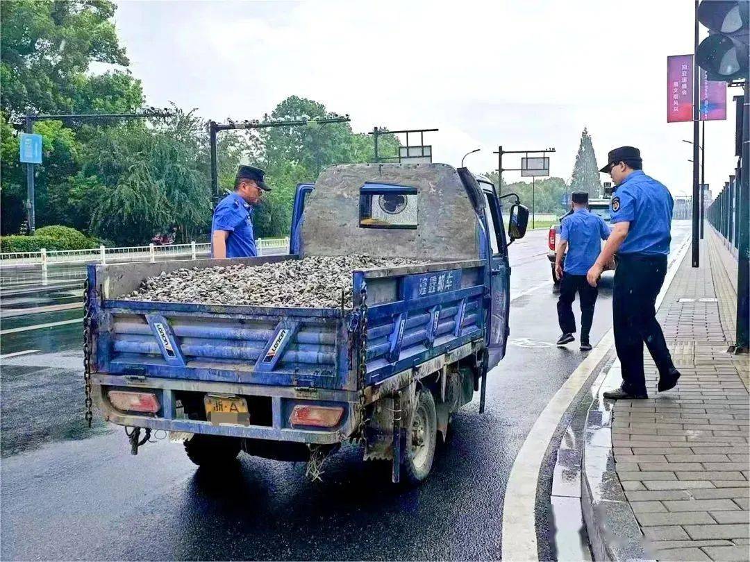 马路中间执法队员在春江街道大桥南路富阳区突发暴雨突发暴雨车遇险