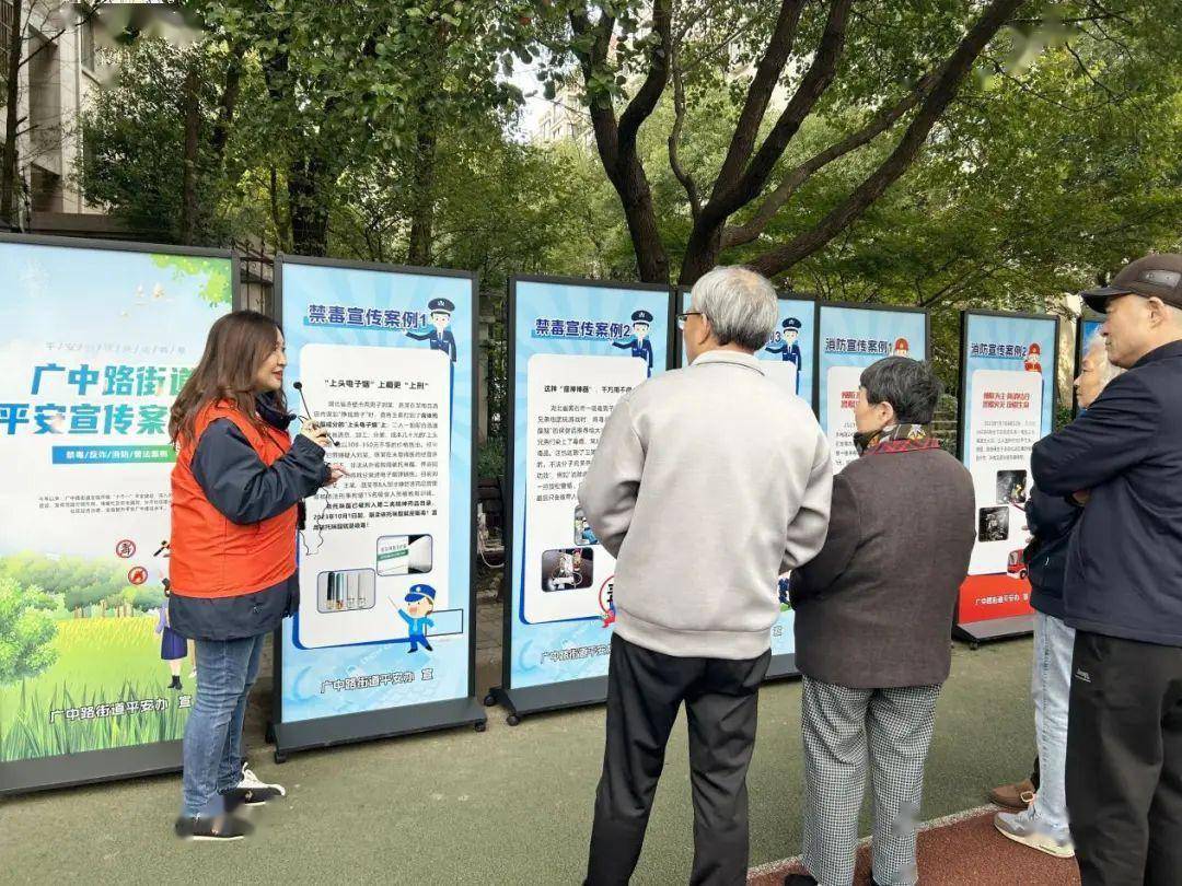 大家驻足在步道边的"平安宣传案例展"展板前,聆听志愿者讲解.