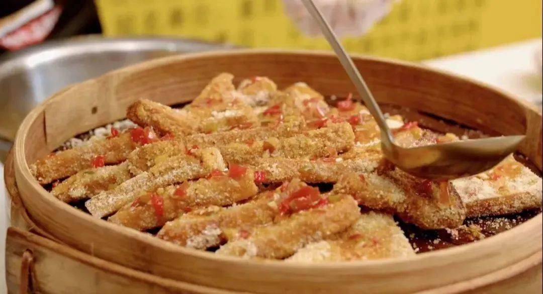 东方会馆的石宝蒸豆腐,采用先炸,后炒料汁浸泡,裹上米面反复淋酱汁蒸