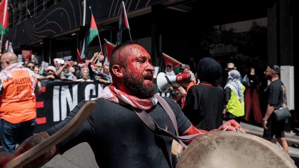 参与者挥舞着绿,红,白三色的巴勒斯坦国旗,举着谴责加沙地带暴力的