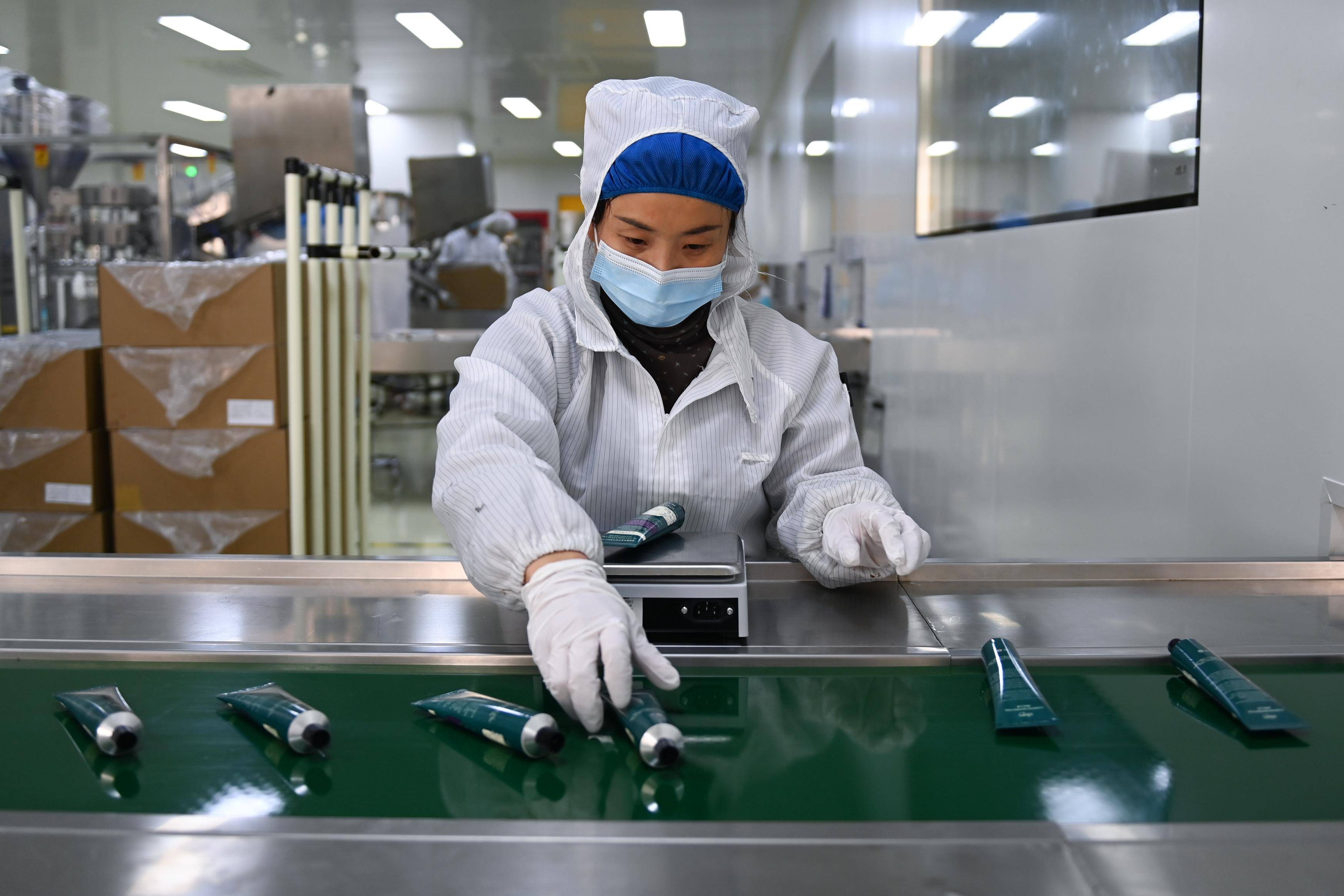 12月21日,工人在"美妆小镇"内一家化妆品生产企业的护手霜灌装车间